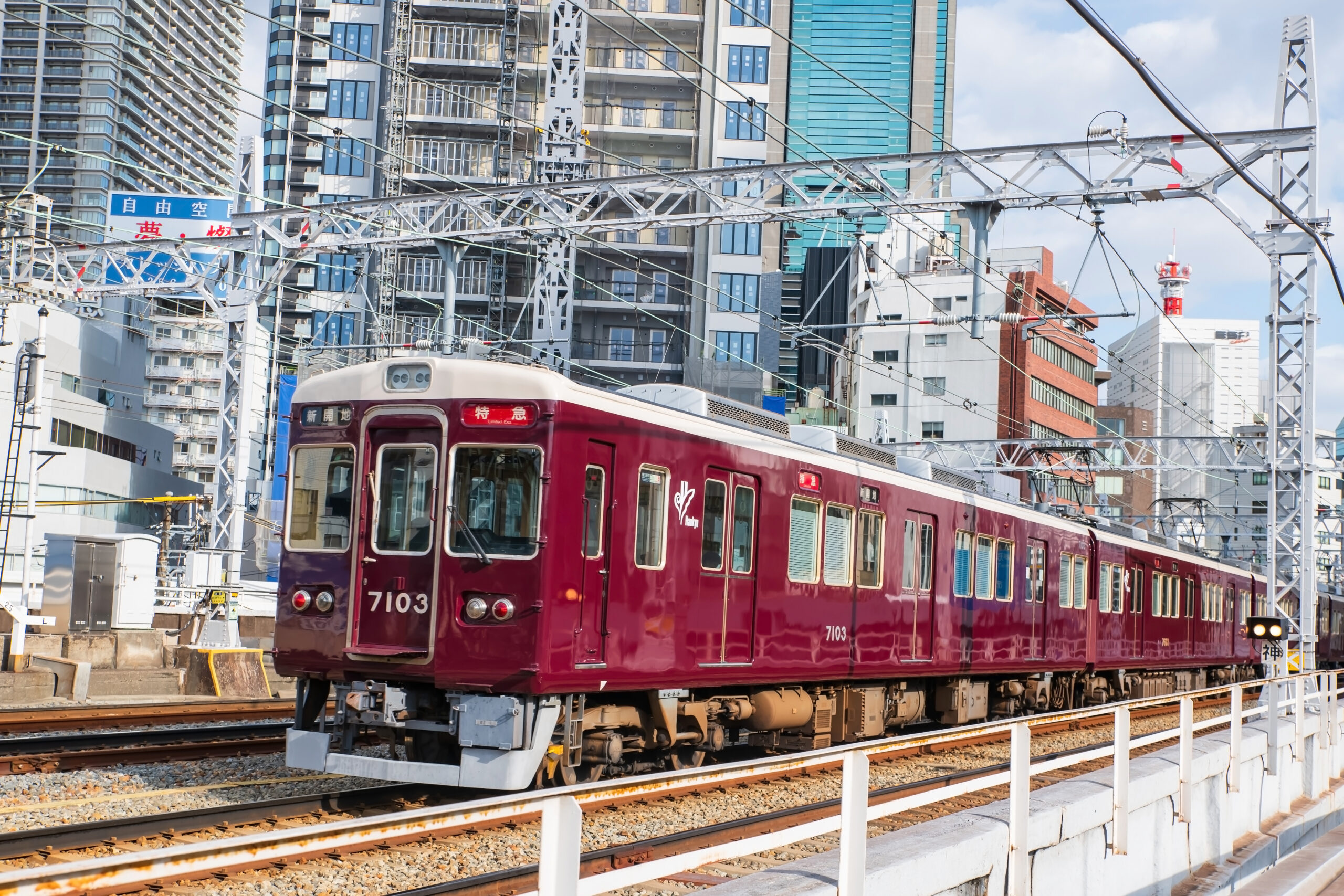 Osaka, Japan - December 11, 2024: Hankyu train on railway with beautiful view of high rise building at Umeda area. Famous travel destination for observation deck to see top view city.