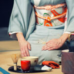 Woman with light blue kimono during a traditional tea ceremony