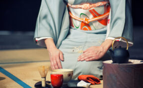Woman with light blue kimono during a traditional tea ceremony
