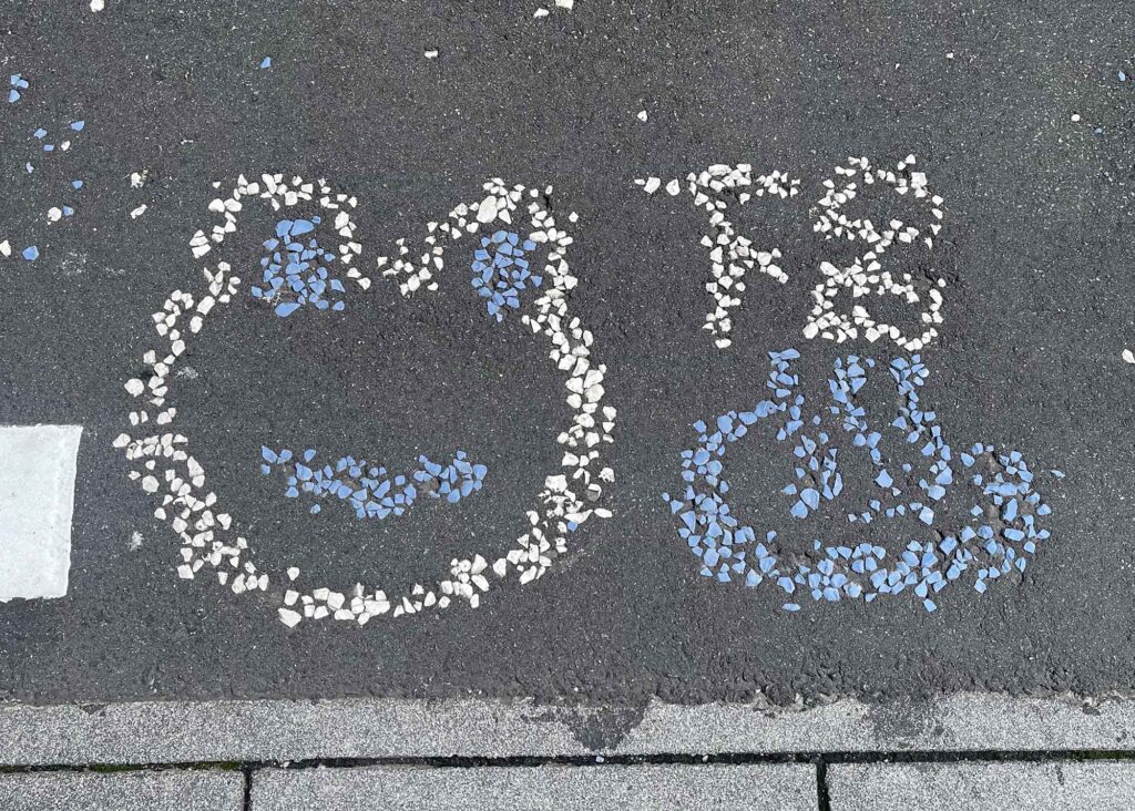 道路に石で描かれたカエル